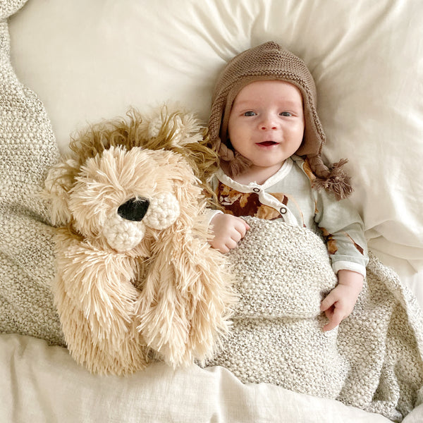 Baby next to a handmade plush lion lovey by ClaraLoo. The lion blanket is made with soft tan faux fur and crocheted accents.
